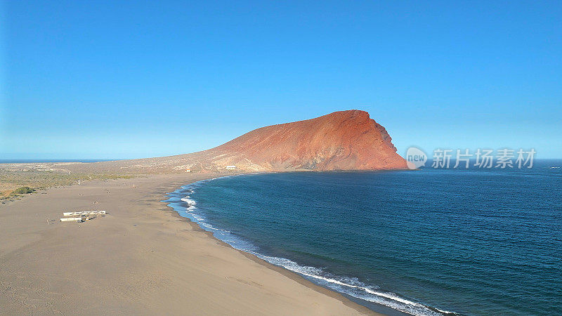 Aerial view of La Tejita Beach and volcanic cone of Montaña Roja, Tenerife, Canary Islands. Drone shot